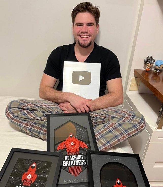 Guilherme Grillo com a placa do YouTube e prêmios da Hotmart